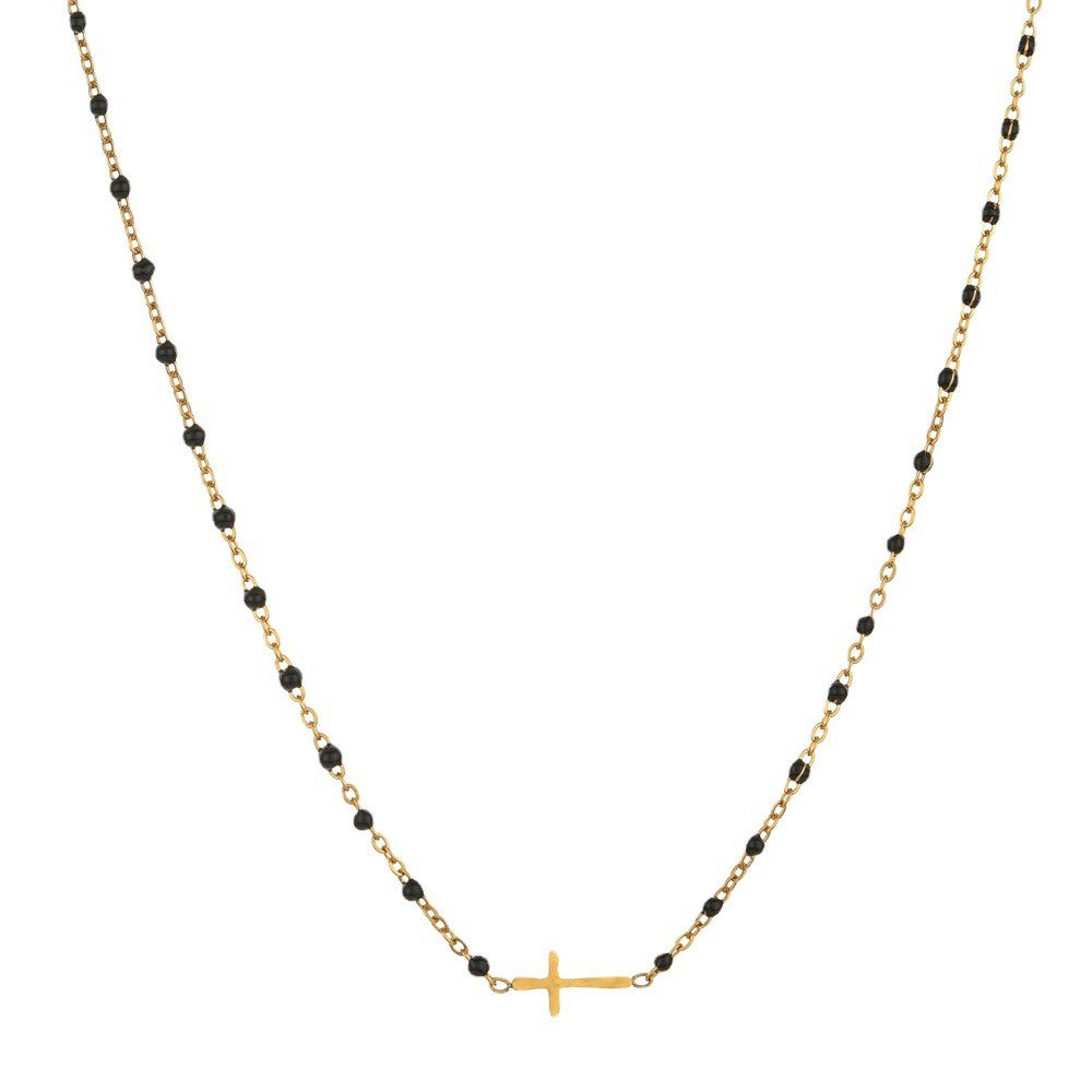 Black beaded gold cross charm stainless steel necklace on white background
