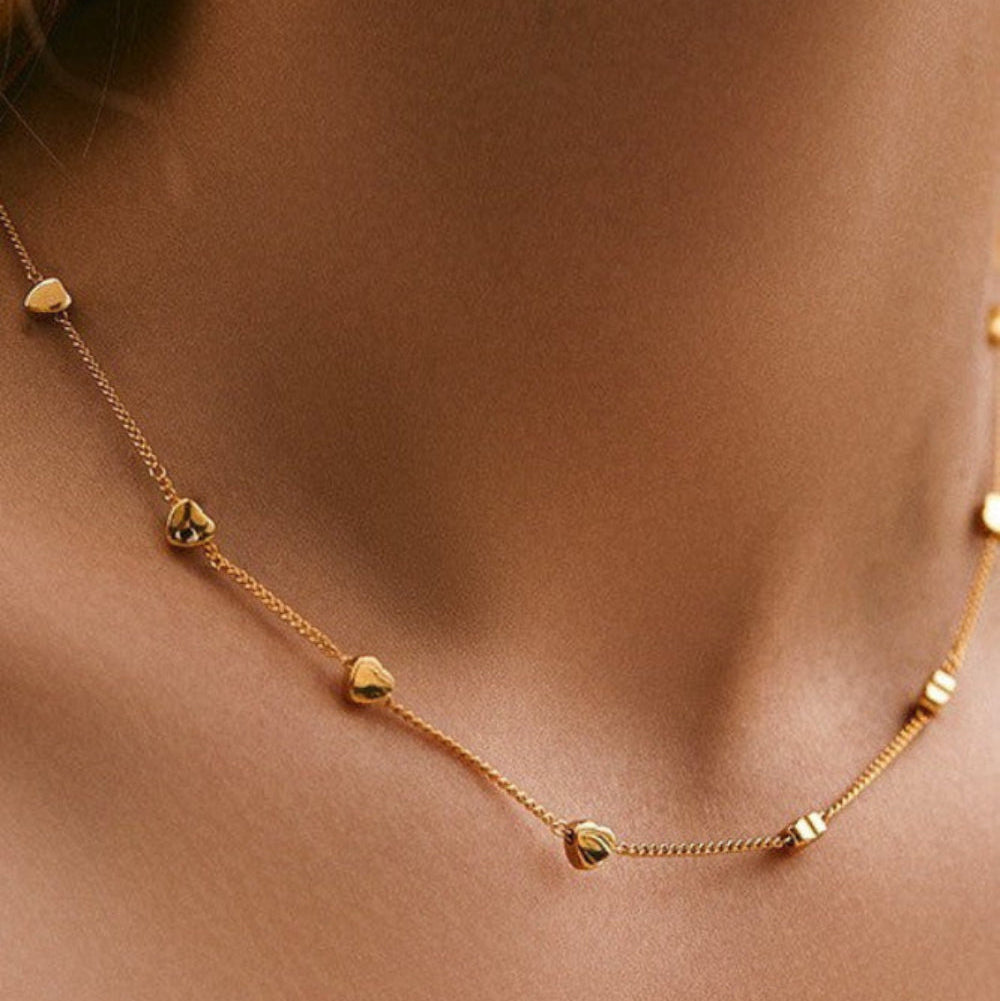 18K gold puffy heart station necklace worn on model