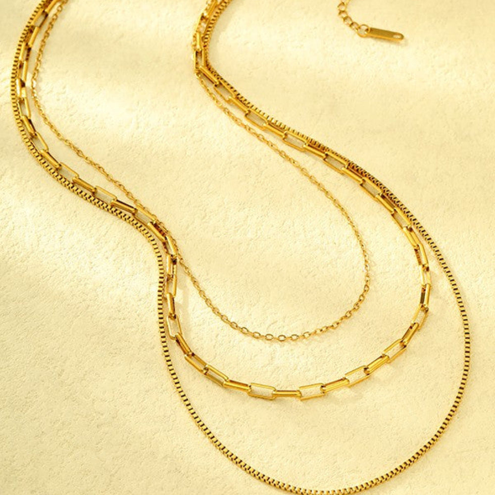 18K gold layered link and box chain necklace flat lay