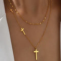 Layered gold cross pendant chain necklace worn on neck showing multiple cross charms