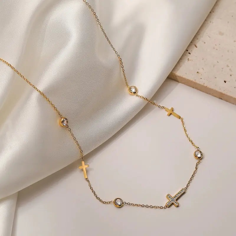 18K Gold Rhinestone Cross & Circular Charm Station Necklace gold close-up detail on silk background