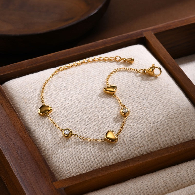 Qua 18K Gold Heart and Rhinestone Station Bracelet on jewelry display