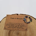 Take A Breath Amethyst Moss Agate Clear Quartz Cross Ring with affirmation card on wood display