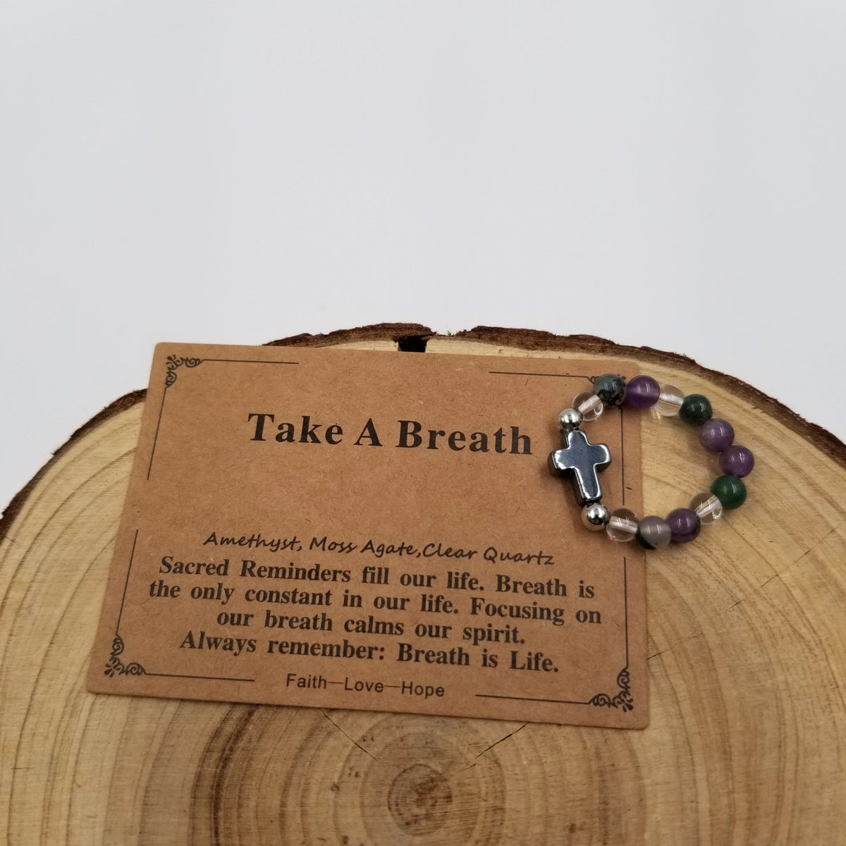Take A Breath Amethyst Moss Agate Clear Quartz Cross Ring with affirmation card on wood display