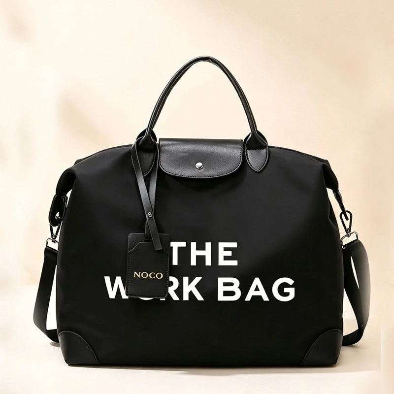 Black Caryall The Work Bag with white lettering, top handles, and a clip-on shoulder strap