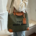 Olive Caryall The Work Bag with brown handles and trim, black lettering, and an adjustable shoulder strap worn by a model