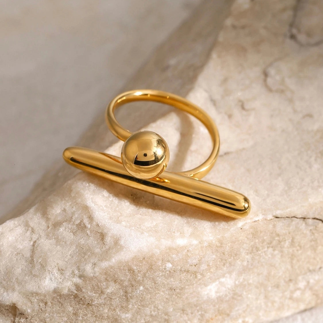 Tory Geometric Ring in 18K gold on stone surface