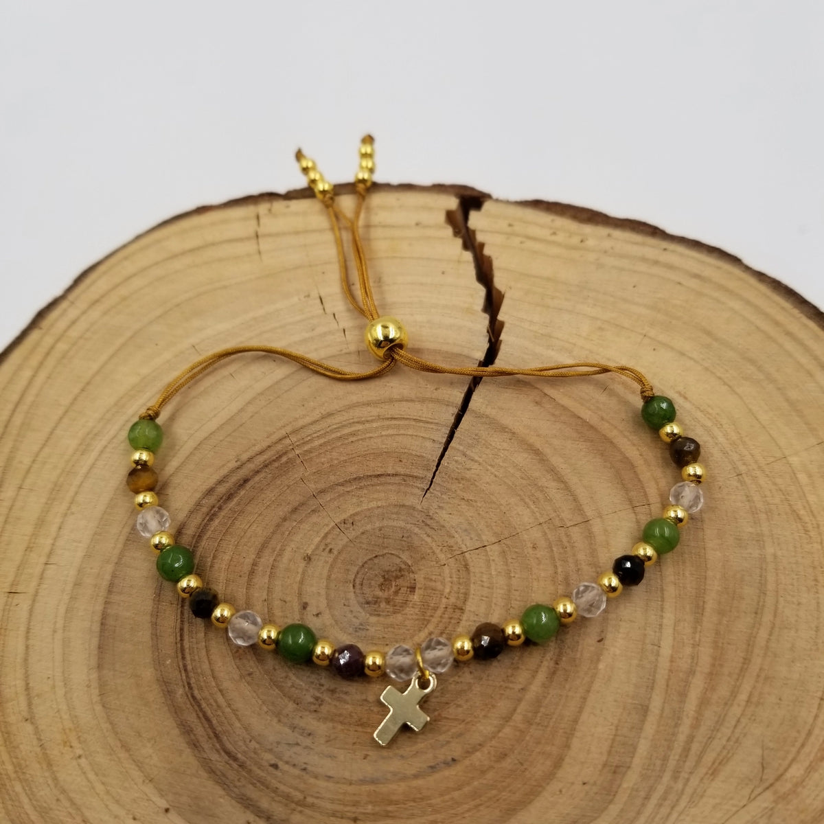 Henrietta 4mm Natural Stone Gold Cross Bracelet on wood display