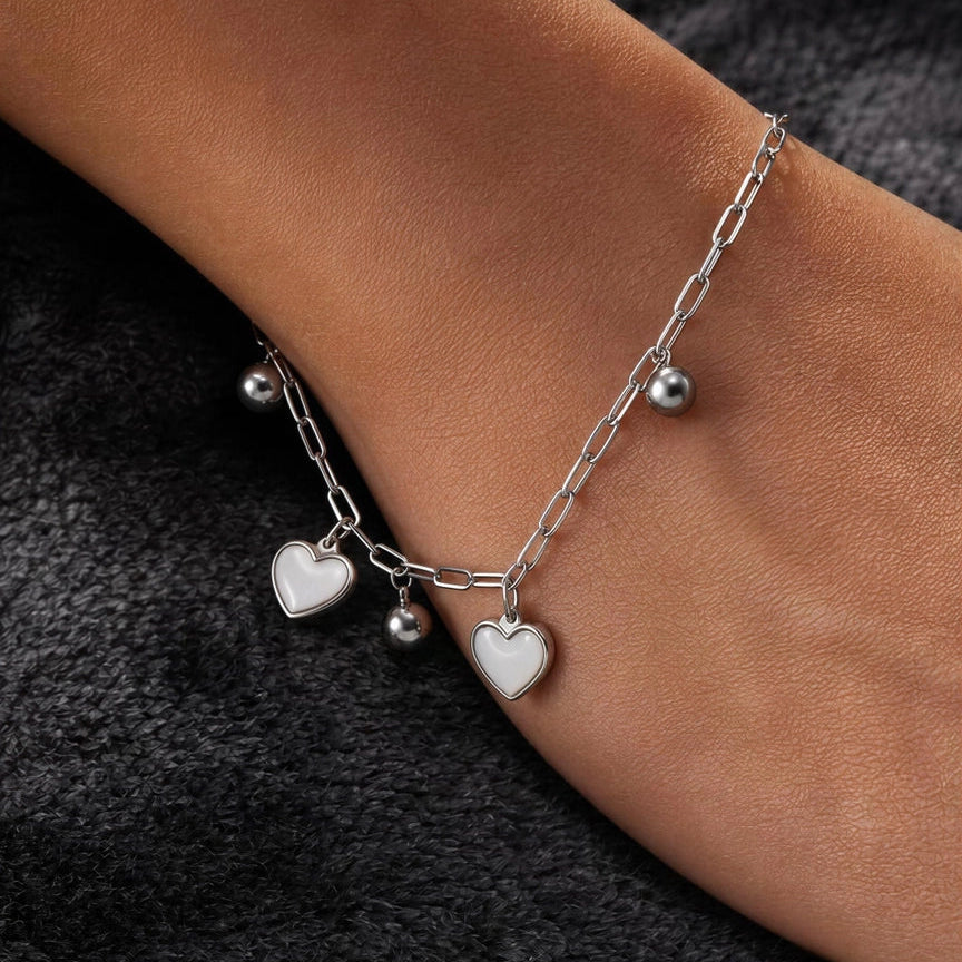 Lyra Love Charm Bracelet with iridescent heart charms and polished bead accents on wrist