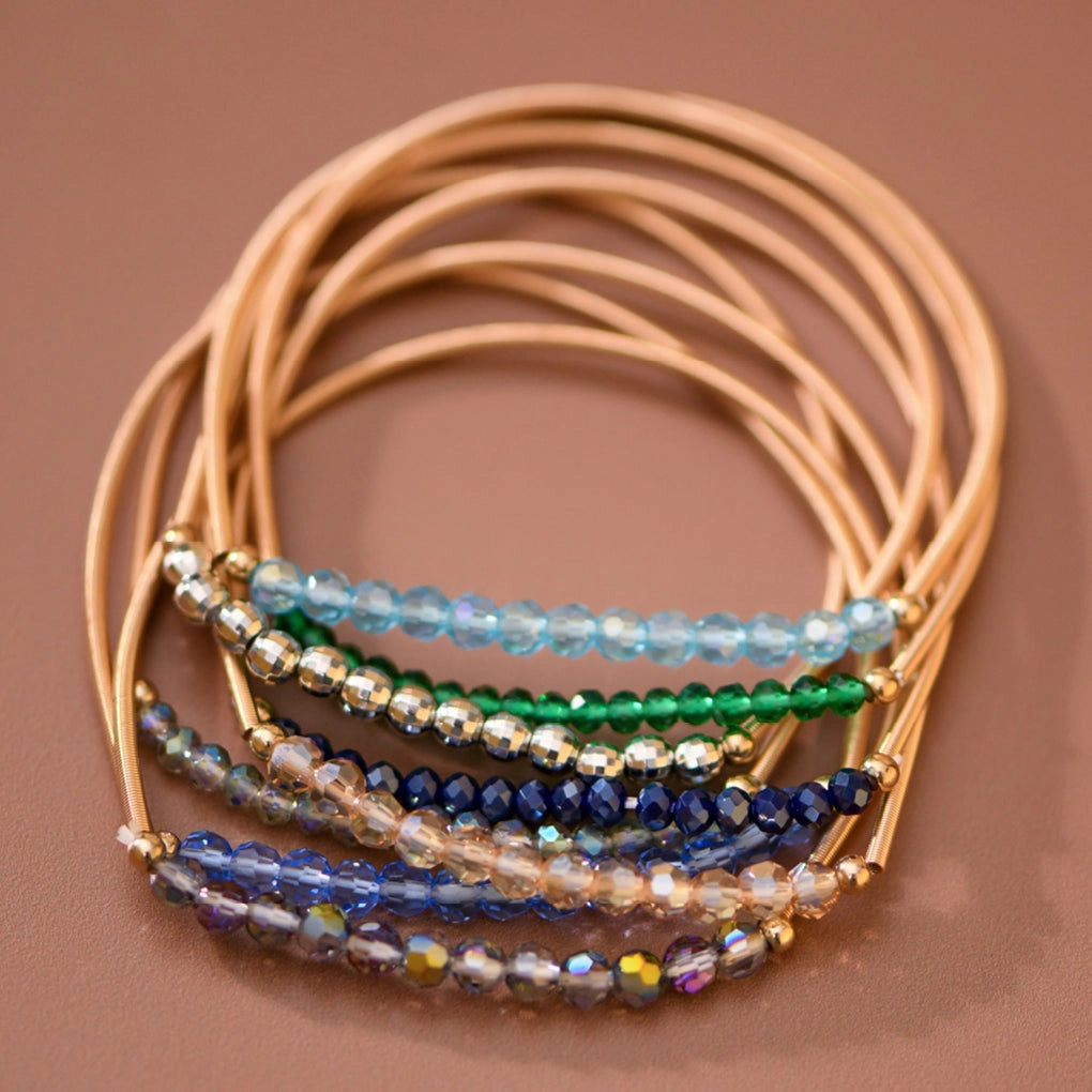 Mica Boho Blue bracelet set with gold-tone spring coil bands and shimmering blue, green, and neutral beads