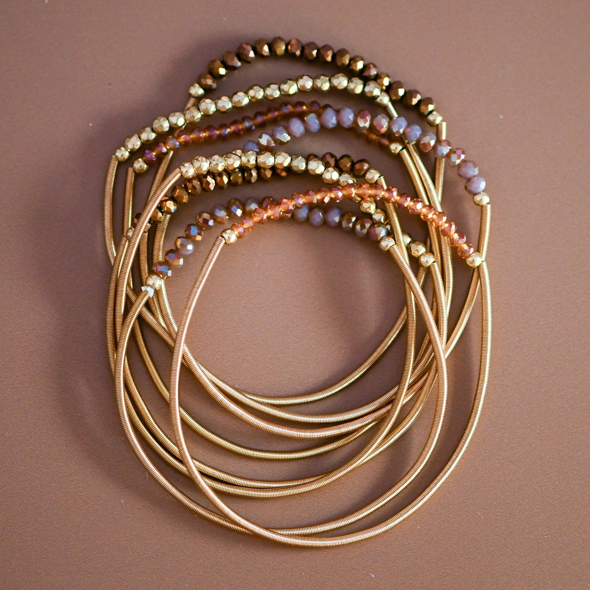 Mica Boho Brown bracelet set with gold-tone spring coil bands and shimmering brown, amber, and gold-tone beads