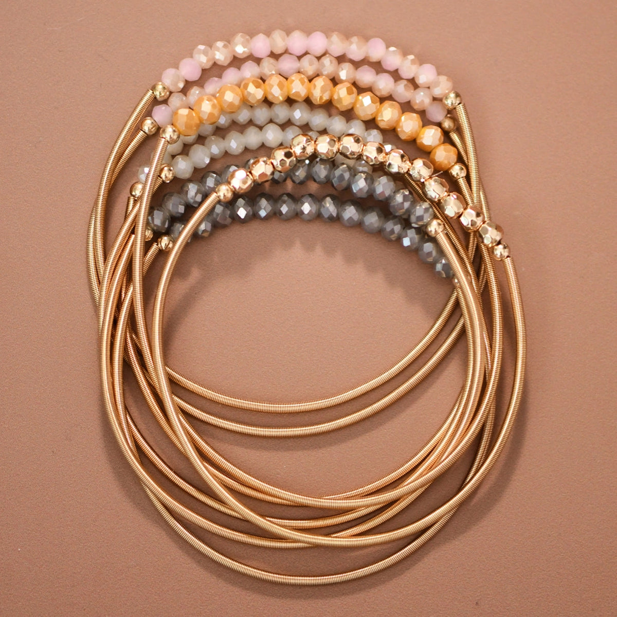 Mica Neutral Boho bracelet set with gold-tone spring coil bands and pink, cream, gray, and gold-tone beads