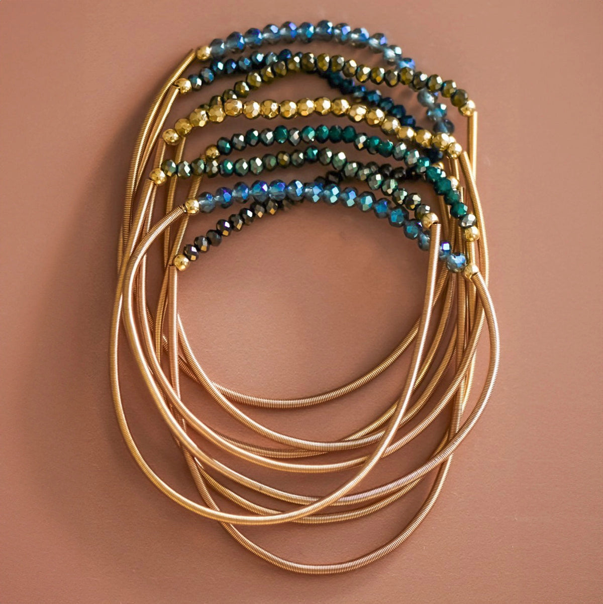 Mica Boho Green bracelet set with gold-tone spring coil bands and shimmering green, blue, and gold-tone beads