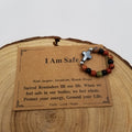 I Am Safe Red Jasper Unakite Black Onyx Cross Ring with affirmation card on wood display