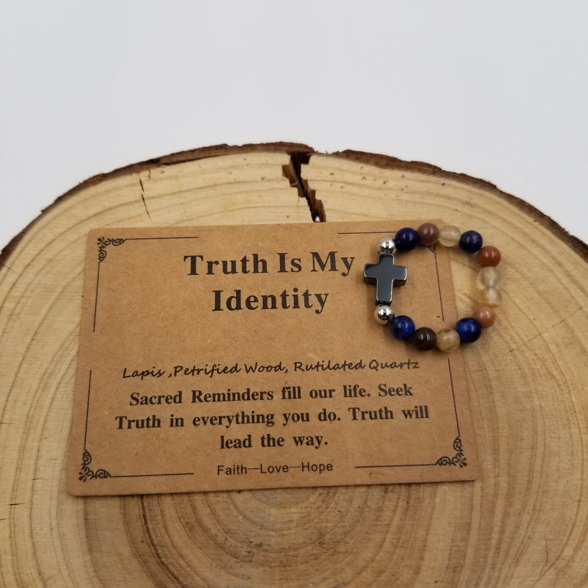Truth Is My Identity Lapis Petrified Wood Rutilated Quartz Cross Ring with affirmation card on wood display
