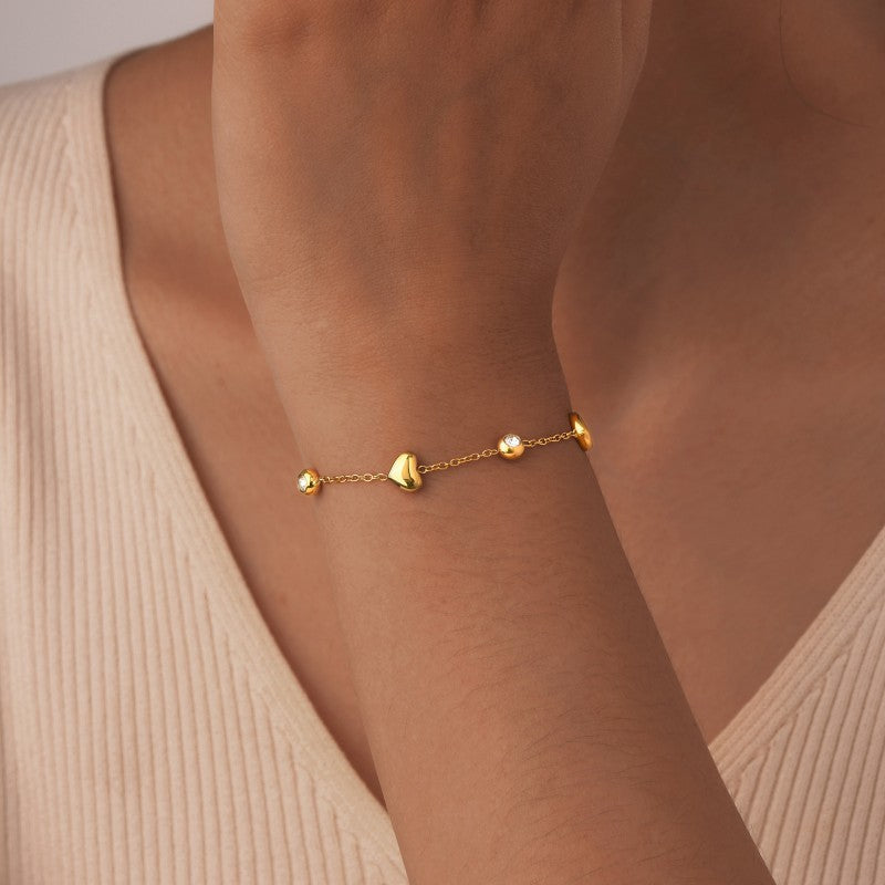 Qua 18K Gold Heart and Rhinestone Station Bracelet worn on wrist