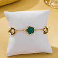 Iris Four Leaf Enamel Charm Bracelet in green on display pillow